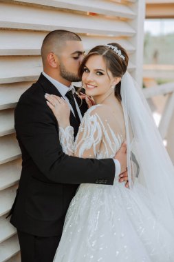 Genç bir gelin ve damat sonbahar güneşinin ışınlarında şefkatle kucaklaşır. Şefkatli ve güzel genç kız gelin. Bir adam sevgilisini öper. Güzel bir bahçenin arka planında