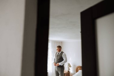 Düğünden önce damadın elleri ceketini bağlar. Takım elbiseli bir adamın yakın çekimi. İş adamı takım elbise giyer. Adam ceketinin düğmelerini bağlıyor..