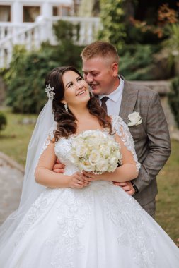 Genç bir gelin ve damat sonbahar güneşinin ışınlarında şefkatle kucaklaşır. Şefkatli ve güzel genç kız gelin. Bir adam sevgilisini öper. Güzel bir bahçenin arka planında