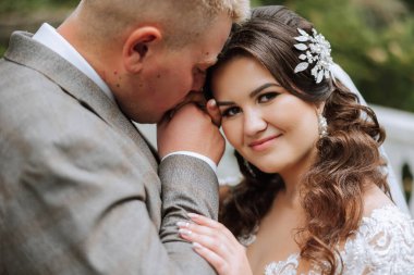 Genç bir gelin ve damat sonbahar güneşinin ışınlarında şefkatle kucaklaşır. Şefkatli ve güzel genç kız gelin. Bir adam sevgilisini öper. Güzel bir bahçenin arka planında