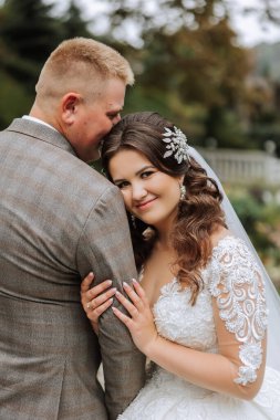 Sonbahar parkında yürüyüş yapan düğün çifti. Güzel beyaz elbiseli gelin. Aşk ve ilişki kavramı. Doğada damat ve gelin