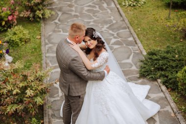 Genç bir gelin ve damat sonbahar güneşinin ışınlarında şefkatle kucaklaşır. Şefkatli ve güzel genç kız gelin. Bir adam sevgilisini öper. Güzel bir bahçenin arka planında