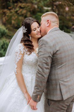 Genç bir gelin ve damat sonbahar güneşinin ışınlarında şefkatle kucaklaşır. Şefkatli ve güzel genç kız gelin. Bir adam sevgilisini öper. Güzel bir bahçenin arka planında