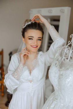 İnanılmaz güzel bir gelinin sabah hazırlığı. İçeride bir mankenin üzerinde duran gelinliğin yanında güzel bir bornoz giymiş bir kız. Gelinin düğün hazırlıkları..