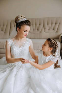 Gelinin portresi ve küçük kız kardeşi odada. Küçük kız kardeşiyle güzel bir gelinin şefkatli ve tatlı fotoğrafı..