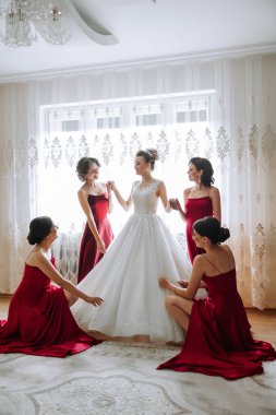 Nedimeler sabahları seviniyor, gelinliğin düğmelerini bağlayıp düğün törenine hazırlanıyorlar. Fotoğraf çekerler, gülümserler, geline ayakkabıları için yardım ederler..