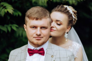 Genç bir gelin ve damat sonbahar güneşinin ışınlarında şefkatle kucaklaşır. Şefkatli ve güzel genç kız gelin. Bir adam sevgilisini öper. Güzel bir bahçenin arka planında