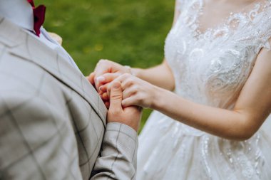 Birlikte dünyayı daha iyi hale getiririz. Evli çiftin el ele tutuşmasını yakından izliyoruz. Gelin ve damat el ele.