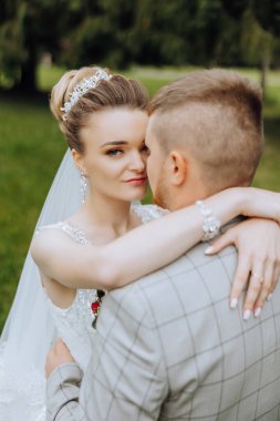 Genç bir gelin ve damat sonbahar güneşinin ışınlarında şefkatle kucaklaşır. Şefkatli ve güzel genç kız gelin. Bir adam sevgilisini öper. Güzel bir bahçenin arka planında