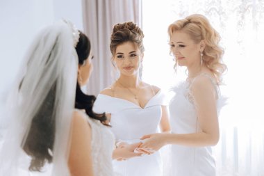 Nedimeler sabahları seviniyor, gelinliğin düğmelerini bağlayıp düğün törenine hazırlanıyorlar. Fotoğraf çekerler, gülümserler, geline ayakkabıları için yardım ederler..