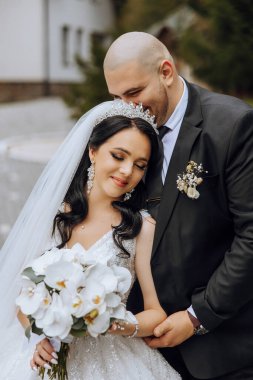 Genç bir gelin ve damat sonbahar güneşinin ışınlarında şefkatle kucaklaşır. Şefkatli ve güzel genç kız gelin. Bir adam sevgilisini öper. Güzel bir bahçenin arka planında