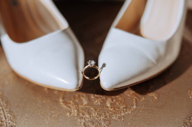 Şık alyanslar. Gelin ve damadın mektupları. Nişan sözü veriyor. Lüks evlilik ve düğün aksesuarı konsepti. İki alyans ve bir düğün davetiyesi.