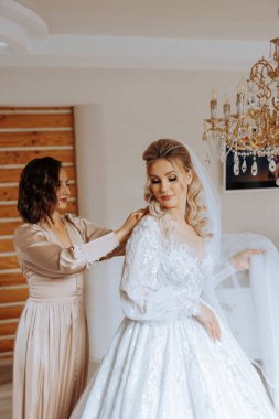 Nedimeler sabahları seviniyor, gelinliğin düğmelerini bağlayıp düğün törenine hazırlanıyorlar. Fotoğraf çekerler, gülümserler, geline ayakkabıları için yardım ederler..