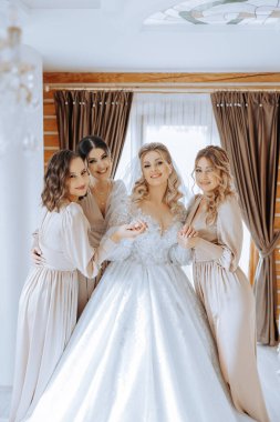 Gelin ve arkadaşlarının portresi. Şık ve şık bir gelin ve arkadaşları sabahları aynı elbiselerle odada. Bir fotoğrafta bir sürü güzel kız var..