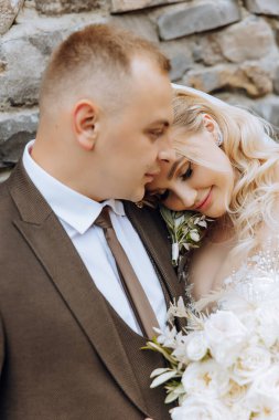 Genç bir gelin ve damat sonbahar güneşinin ışınlarında şefkatle kucaklaşır. Şefkatli ve güzel genç kız gelin. Bir adam sevgilisini öper. Güzel bir bahçenin arka planında