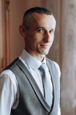 Resmi takım elbiseli başarılı beyaz adam portresi, odada poz veren, kameraya bakan mutlu genç erkek patron veya CEO, güven ve güç, liderlik konsepti