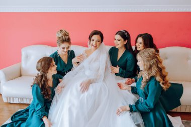 Nedimeler sabahları seviniyor, gelinliğin düğmelerini bağlayıp düğün törenine hazırlanıyorlar. Fotoğraf çekerler, gülümserler, geline ayakkabıları için yardım ederler..