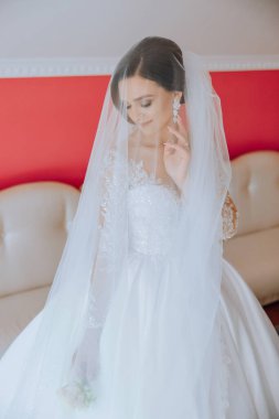 Beyaz gelinlik içinde duvak tutan genç bir gelin otel odasında esmer gelin portresi, düğünden önceki sabah..