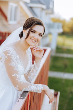 Düğün portresi. Dantelli, omuzları açık, esmer bir gelin doğada poz veriyor. Güzel saç ve makyaj. Sonbahar. Gün ışığı. kutlama.