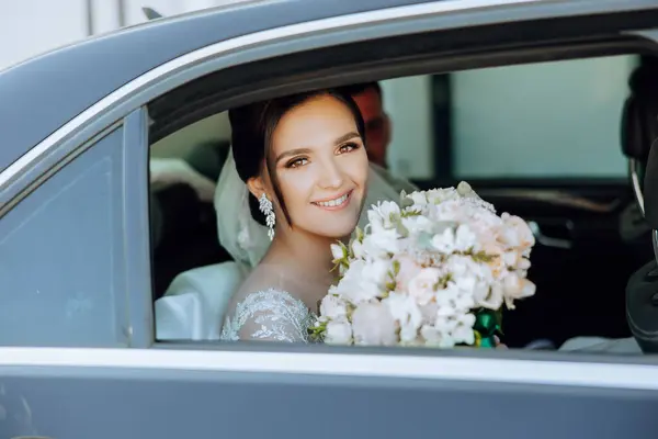 신부는 그녀의 꽃다발과 밖으로 보인다 자동차에서 오히려 수줍은 신부의 초상화 — 스톡 사진
