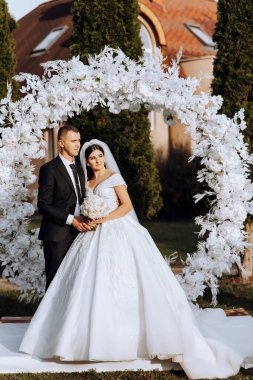 Genç bir gelin ve damat sonbahar güneşinin ışınlarında şefkatle kucaklaşır. Şefkatli ve güzel genç kız gelin. Bir adam sevgilisini öper. Güzel bir bahçenin arka planında