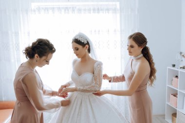 Nedimeler sabahları seviniyor, gelinliğin düğmelerini bağlayıp düğün törenine hazırlanıyorlar. Fotoğraf çekerler, gülümserler, geline ayakkabıları için yardım ederler..