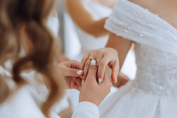 Wedding bride and bridesmaid help with jewellery bracelet for elegant and classic fashion glamour. Expensive bridal diamond accessory for classy style at special ceremony event day closeup.
