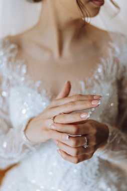 Modern bir manikür ve güneş ışığıyla bir kadının parmağına takılmış zarif bir elmas yüzüğün yakın çekimi. Aşk ve düğün kavramı. Yumuşak ve seçici odak.