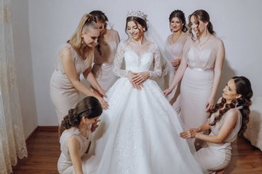 Nedimeler sabahları seviniyor, gelinliğin düğmelerini bağlayıp düğün törenine hazırlanıyorlar. Fotoğraf çekerler, gülümserler, geline ayakkabıları için yardım ederler..