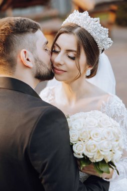 Genç bir gelin ve damat sonbahar güneşinin ışınlarında şefkatle kucaklaşır. Şefkatli ve güzel genç kız gelin. Bir adam sevgilisini öper. Güzel bir bahçenin arka planında