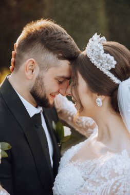 Genç bir gelin ve damat sonbahar güneşinin ışınlarında şefkatle kucaklaşır. Şefkatli ve güzel genç kız gelin. Bir adam sevgilisini öper. Güzel bir bahçenin arka planında