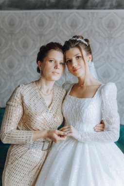 Güzel ve mutlu bir anne ve kızı, gelin, yan yana duruyorlar. Ebeveynler için en iyi gün. Düğünde hassas anlar.