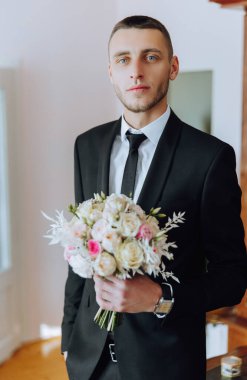 Bir buket güllü damat, buketli damat, düğün buketli damat, elinde düğün buketi olan genç bir adam, çok uygun bir adam.