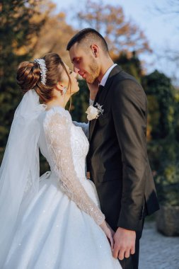 Genç bir gelin ve damat sonbahar güneşinin ışınlarında şefkatle kucaklaşır. Şefkatli ve güzel genç kız gelin. Bir adam sevgilisini öper. Güzel bir bahçenin arka planında