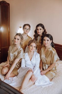 Gelin ve arkadaşlarının portresi. Şık ve şık bir gelin ve arkadaşları sabahları aynı elbiselerle odada. Bir fotoğrafta bir sürü güzel kız var..