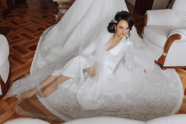 İnanılmaz güzel bir gelinin sabah hazırlığı. İçeride bir mankenin üzerinde duran gelinliğin yanında güzel bir bornoz giymiş bir kız. Gelinin düğün hazırlıkları..