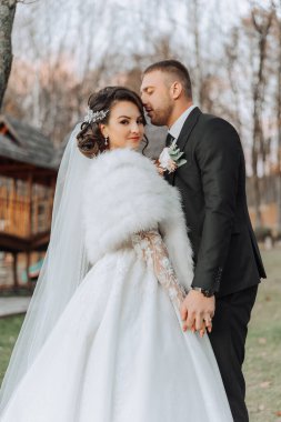 Genç bir gelin ve damat sonbahar güneşinin ışınlarında şefkatle kucaklaşır. Şefkatli ve güzel genç kız gelin. Bir adam sevgilisini öper. Güzel bir bahçenin arka planında