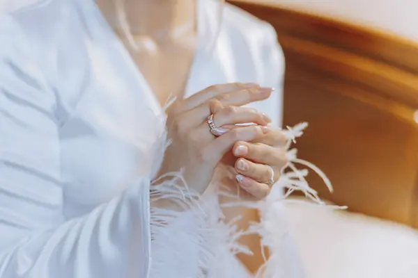 Close-up of an elegant diamond ring on the finger of a woman with a modern manicure. Love and wedding concept. Soft and selective focus.
