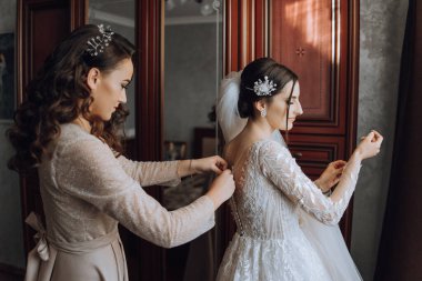 Nedimeler sabahları seviniyor, gelinliğin düğmelerini bağlayıp düğün törenine hazırlanıyorlar. Fotoğraf çekerler, gülümserler, geline ayakkabıları için yardım ederler..