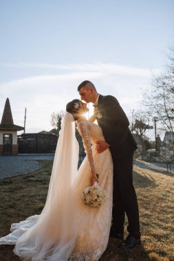 Genç bir gelin ve damat sonbahar güneşinin ışınlarında şefkatle kucaklaşır. Şefkatli ve güzel genç kız gelin. Bir adam sevgilisini öper. Güzel bir bahçenin arka planında