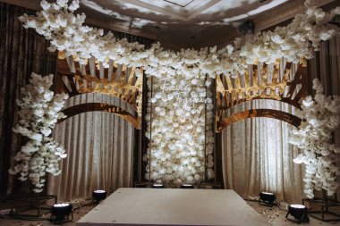 Düğün ya da doğum günü kutlamalarındaki fotoğraf bölgesi çiçeklerle süslenir ve yapay ışıkla aydınlatılır.