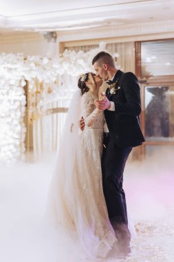 Gelin ve damadın büyük ışık ve atmosferi olan zarif bir restoranda evlenmesi. Gelin ve damadın ilk dansı.