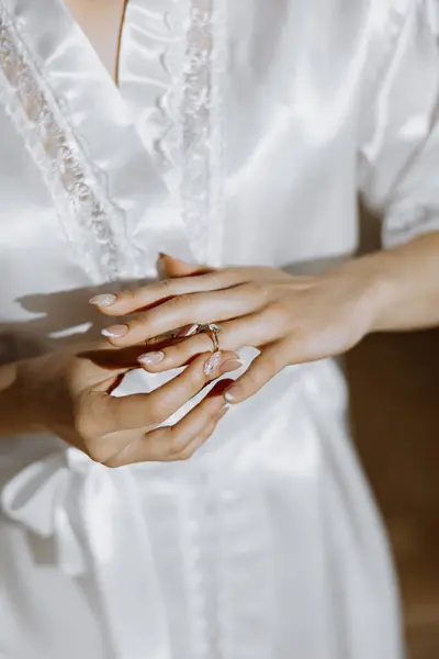 Close-up of an elegant diamond ring on a woman\'s finger with a modern manicure, sunlight. Love and wedding concept. Soft and selective focus.