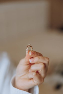 Bir kadın, içinde elmas olan altın bir yüzük tutuyor. Aşk ve bağlılık kavramı, yüzüğün genellikle evlilikle ilişkili olduğu gibi.