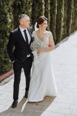 Bir adam ve bir kadın tuğla yolda yürüyorlar, adam takım elbise ve kravat takıyor.