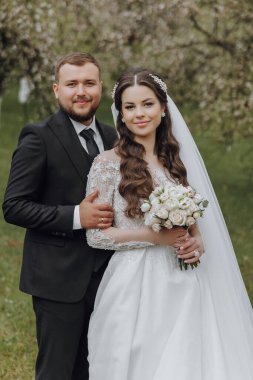 Bir gelin ve damat tarlada fotoğraf için poz veriyor.