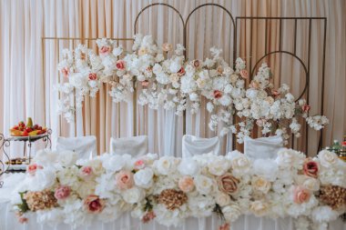 Düğündeki gelin ve damadın başkanlığı çeşitli pembe ve beyaz gül çiçekleriyle süslenmiştir. Düğün hazırlıkları.