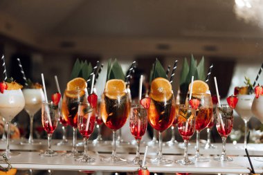 İçinde pipet olan bir masa dolusu içki. İçkiler uzun bardaklarda ve onlardan bir sürü var.