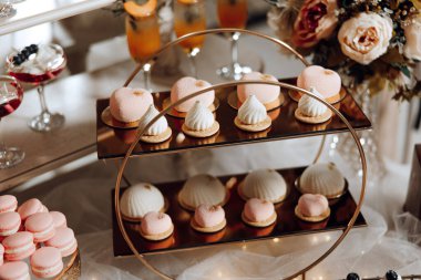 Çeşitli hamur işleri ve pastalarla dolu bir tatlı masası, bazıları krem şantili, bazıları meyveli.