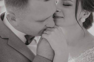 Bir erkek ve bir kadın birbirlerinin ellerini öpüyor. Adam alyans takıyor.